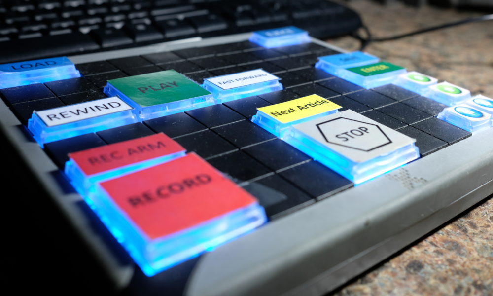 Large glowing labeled buttons on a pad, Record, Stop, Play.