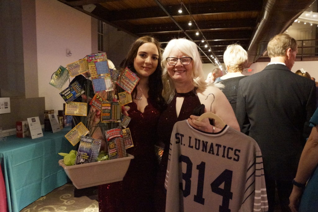 Gateway Archers Mari and Kim Blumenthal show off their silent auction winnings of the lotto ticket tree and Nelly-signed jersey