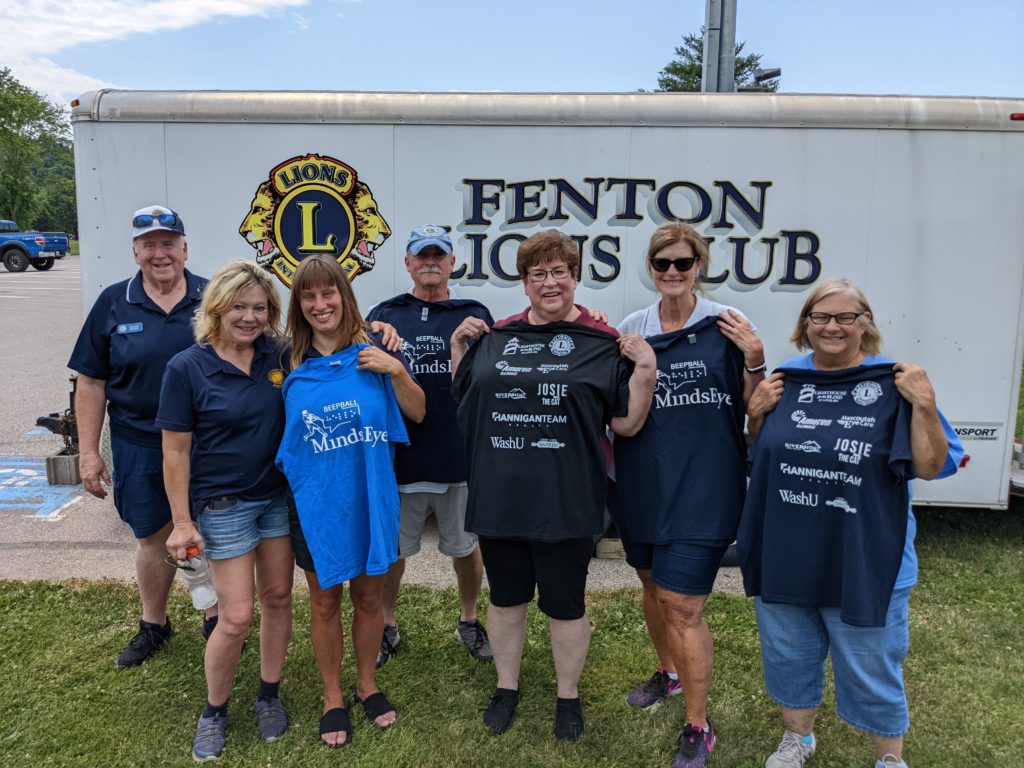 Photo of the Lions BBQ volunteers, holding up BeepBall t-shirts