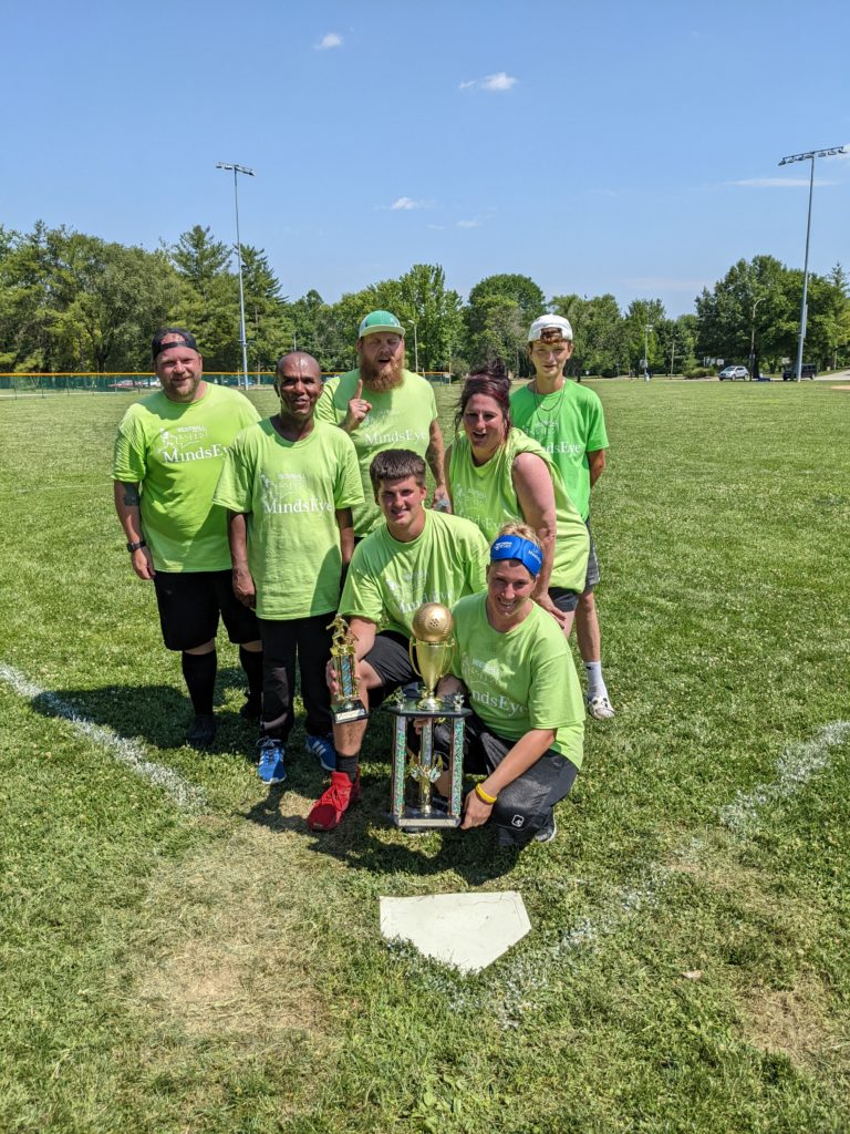 "Bumblebeeps" team photo. They pose around their trophy in lime green shirts.