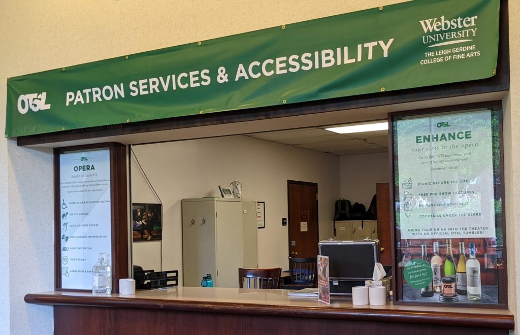 The Patron Services and Accessibility window where MindsEye description team members hand out devices for OTSL. A list on the left lists several accessible services, including ASL and touch tables.