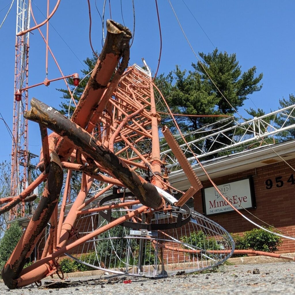 a crumbled radio tower in front and on the MindsEye Studio building