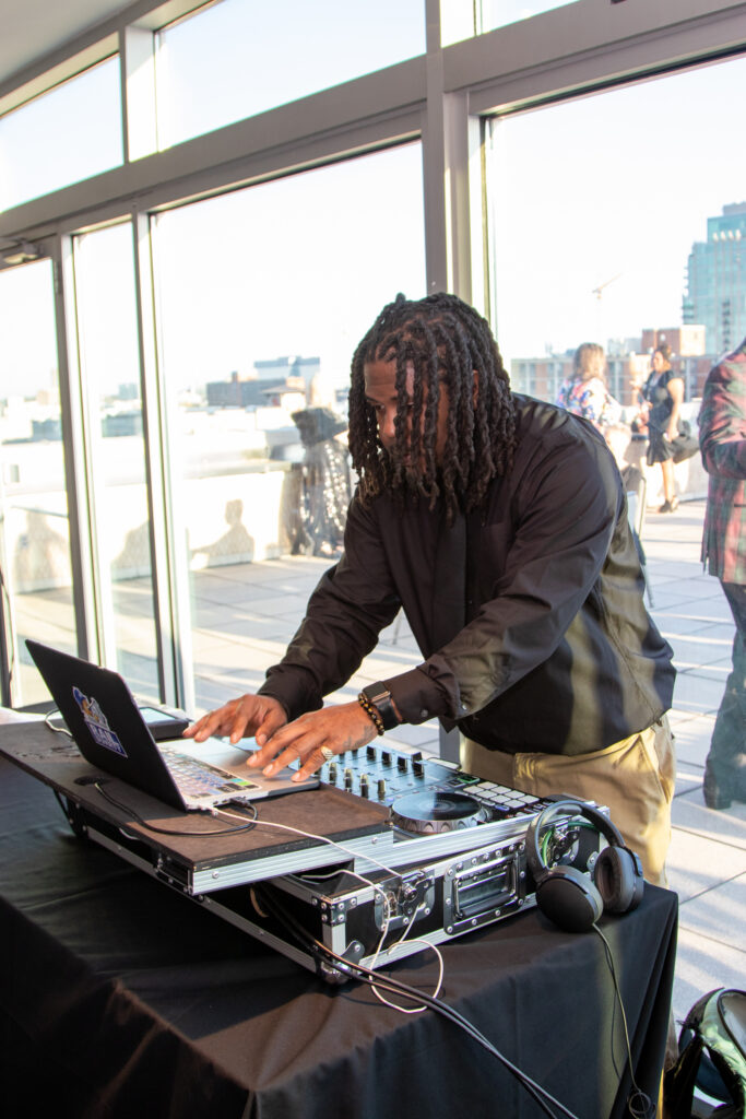 DJ Rail Durrty working the music equipment in front of the balcony of the top floor of the Chase Park Plaza