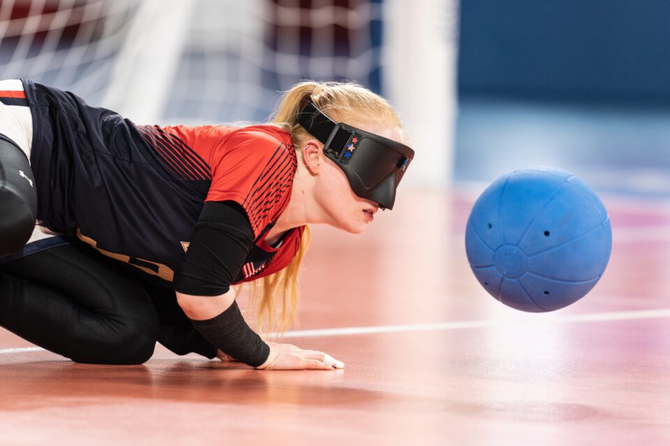 Goalball player attempting to block the ball