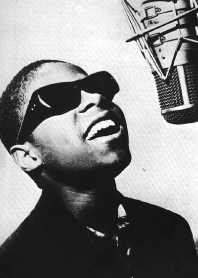 Stevie Wonder singing into a microphone.